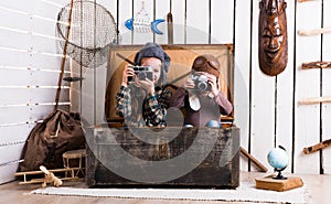 Two little girls in wooden chest playing rarity cameras