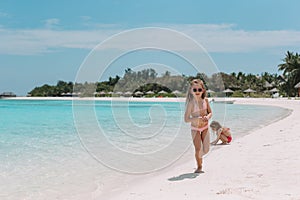 Two little happy girls have a lot of fun at tropical beach playing together