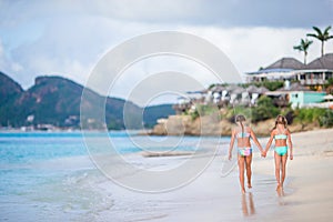 Two little happy girls have a lot of fun at tropical beach playing together