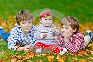 Two little happy kid boys with newborn baby girl, cute sister.