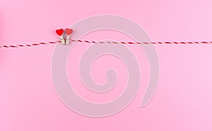 Two little hearts symbol of St. Valentine`s day on a clothespin and string creative postcard, copy space, flat lay