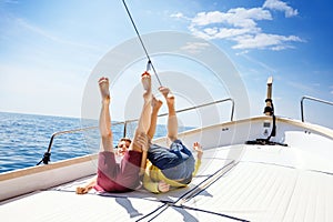 Two little kid boys, best friends enjoying sailing boat trip. Family vacations on ocean or sea on sunny day. Children