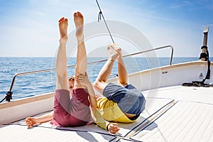 Two little kid boys, best friends enjoying sailing boat trip. Family vacations on ocean or sea on sunny day. Children