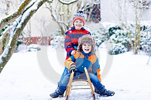 Two little kid boys enjoying sleigh ride in winter