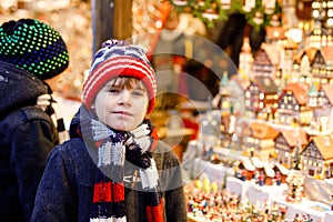 Two little kid boys selecting decoration on Christmas market. Beautiful siblings and best friends shopping for toys and