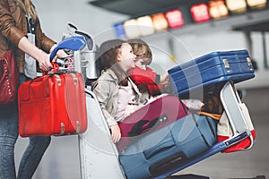 Two little kids, boy and girl, siblings and mother at the airport. Children, family traveling, going on vacation by