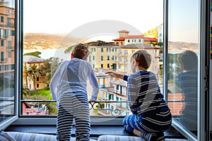 Two little kids boys enjoying view from window in morning on Liguria region in Italy. Awesome villages of Cinque Terre