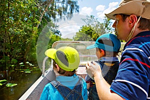 Two little kids boys and father making air boat tour in Everglades Park