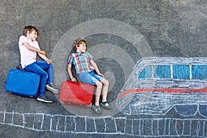 Two little kids boys having fun with train picture drawing with colorful chalks on asphalt. Children having fun with