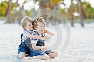 Two little kids boys having fun on tropical beach