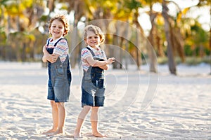 Two little kids boys having fun on tropical beach