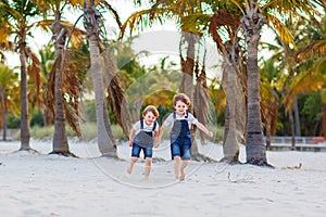 Two little kids boys having fun on tropical beach