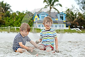 Two little kids boys having fun on tropical beach