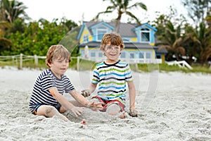 Two little kids boys having fun on tropical beach