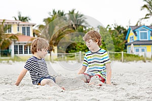 Two little kids boys having fun on tropical beach