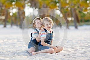 Two little kids boys having fun on tropical beach