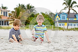 Two little kids boys having fun on tropical beach