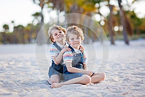 Two little kids boys having fun on tropical beach