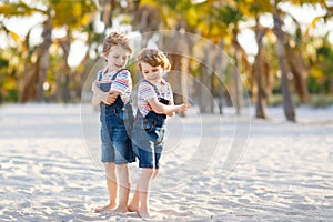 Two little kids boys having fun on tropical beach