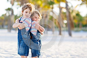 Two little kids boys having fun on tropical beach