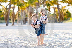 Two little kids boys having fun on tropical beach