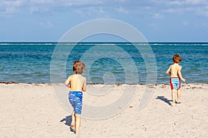 Two little kids boys having fun on tropical beach