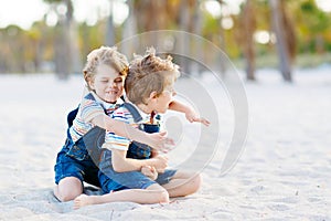 Two little kids boys having fun on tropical beach