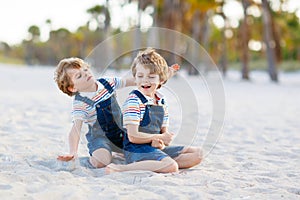 Two little kids boys having fun on tropical beach