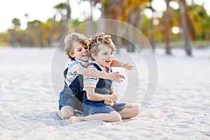 Two little kids boys having fun on tropical beach