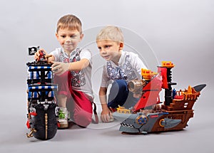 Two little kids boys playing with sailing ship model