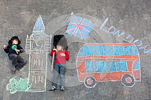 Two little kids with London picture drawing with chalks