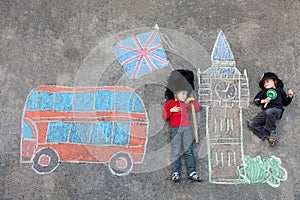 Two little kids with London picture drawing with chalks