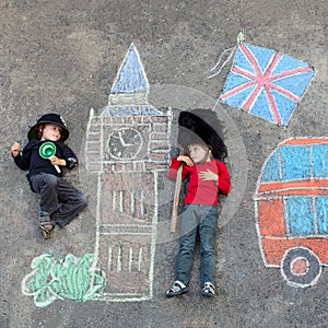Two little kids with London picture drawing with chalks