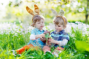 Two little kids playing with Easter chocolate