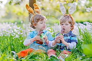 Two little kids playing with Easter chocolate bunny