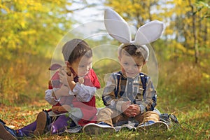 Two little kids playing like bunnies in the park