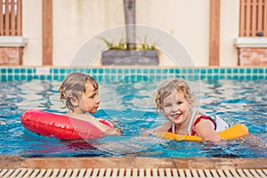 Two little kids playing in the swimming pool