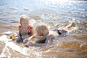 Two Little Kids Playing in the Water at the Beach