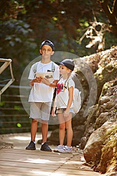 Two little kids read orientation forest map