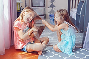 Two little mad angry girls sisters having fight at home photo