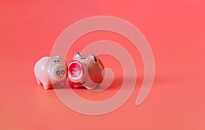 Two little pigs on a pink background. Composition for Valentine`s Day. Finance concept. Piggy bank, animals, figurines. Copy space