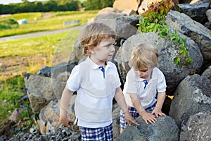 Two little sibling boys having fun outdoors in family look