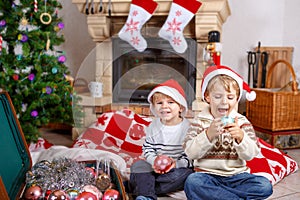 Two little sibling boys playing with christmas toys