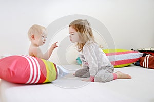 Two little sisters in bed on morning