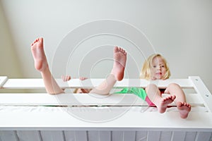 Two little sisters fooling around, playing and having fun in twin bunk bed