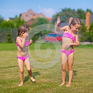 Two little sisters frolicing and splashing in