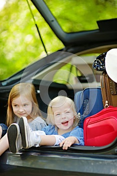 Two little sisters going to a car vacation