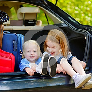 Two little sisters going to a car vacation