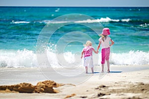 Two little sisters having fun on a beach