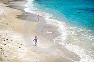 Two little sisters having fun on a beach